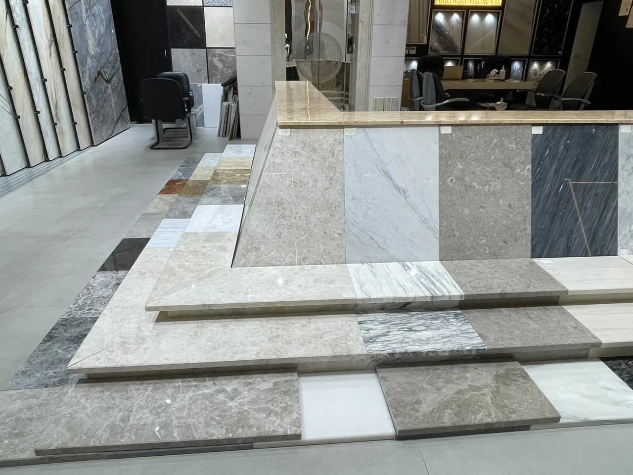 Marble stair-step display in the showroom, with sample slabs and the office behind