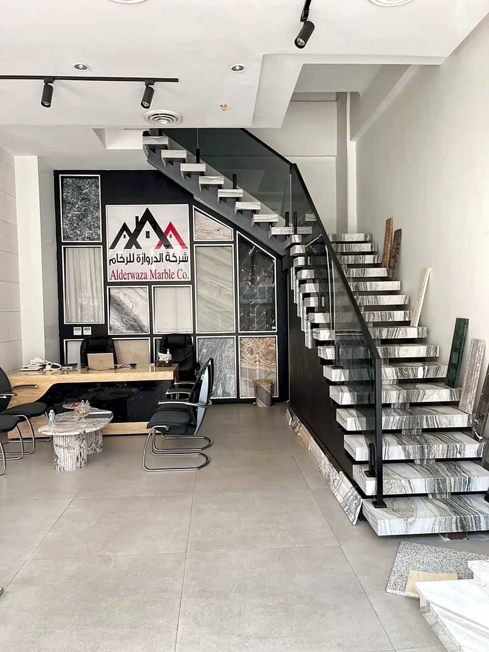 Floating staircase in grey-veined marble beside a stone feature wall