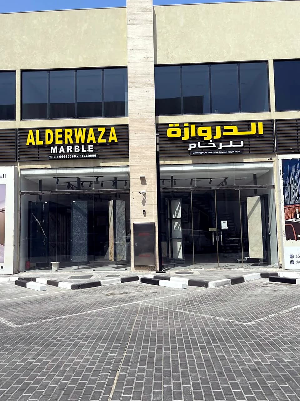 Alderwaza Marble showroom front with its English and Arabic signs and parking in front