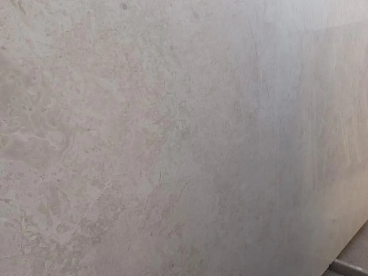 Slab of omani Dark (Omani Gamej) marble, warm beige with soft clouding, at the stone yard