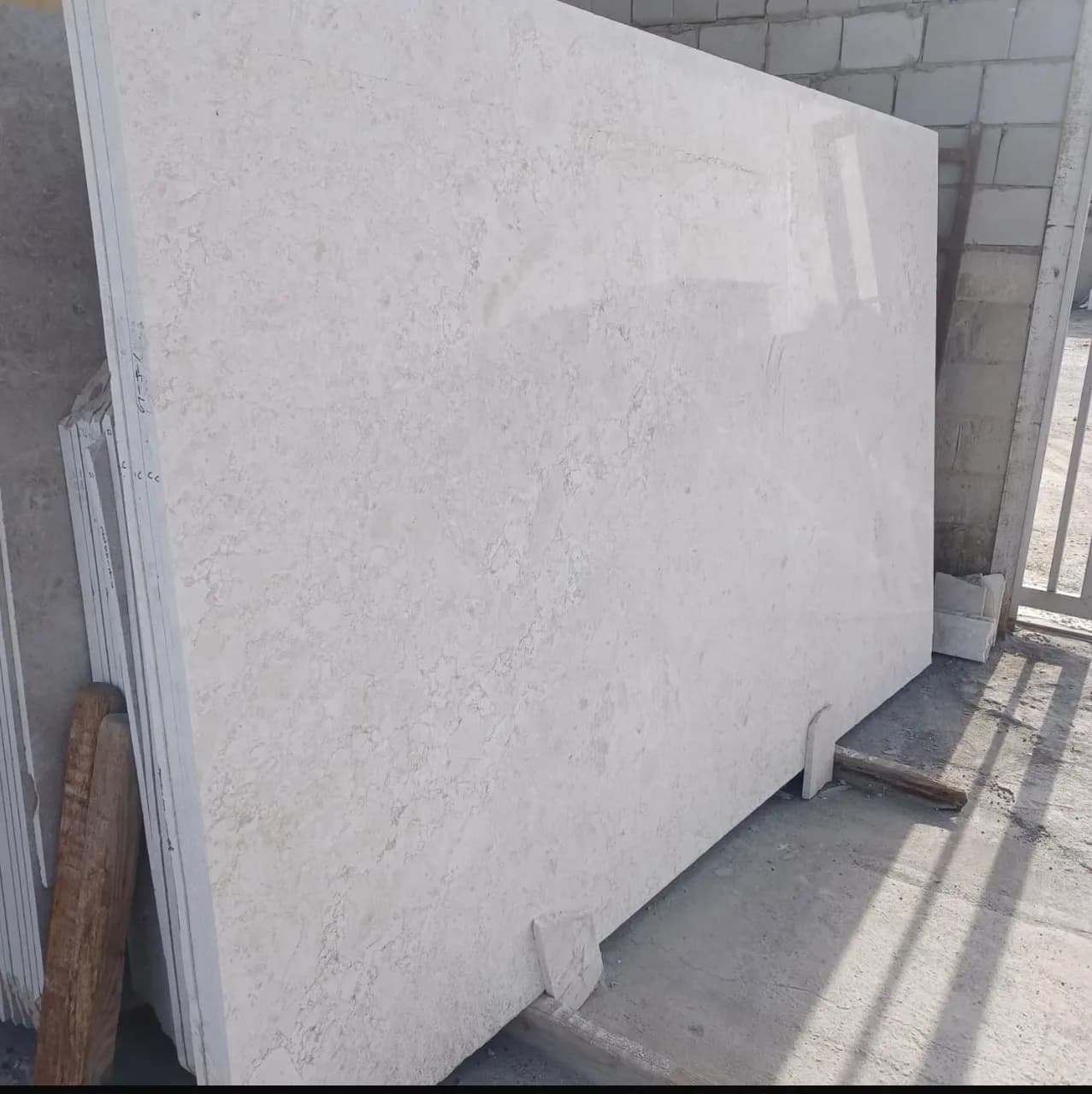 Polished light beige Omani marble slab standing in the Alderwaza stone yard